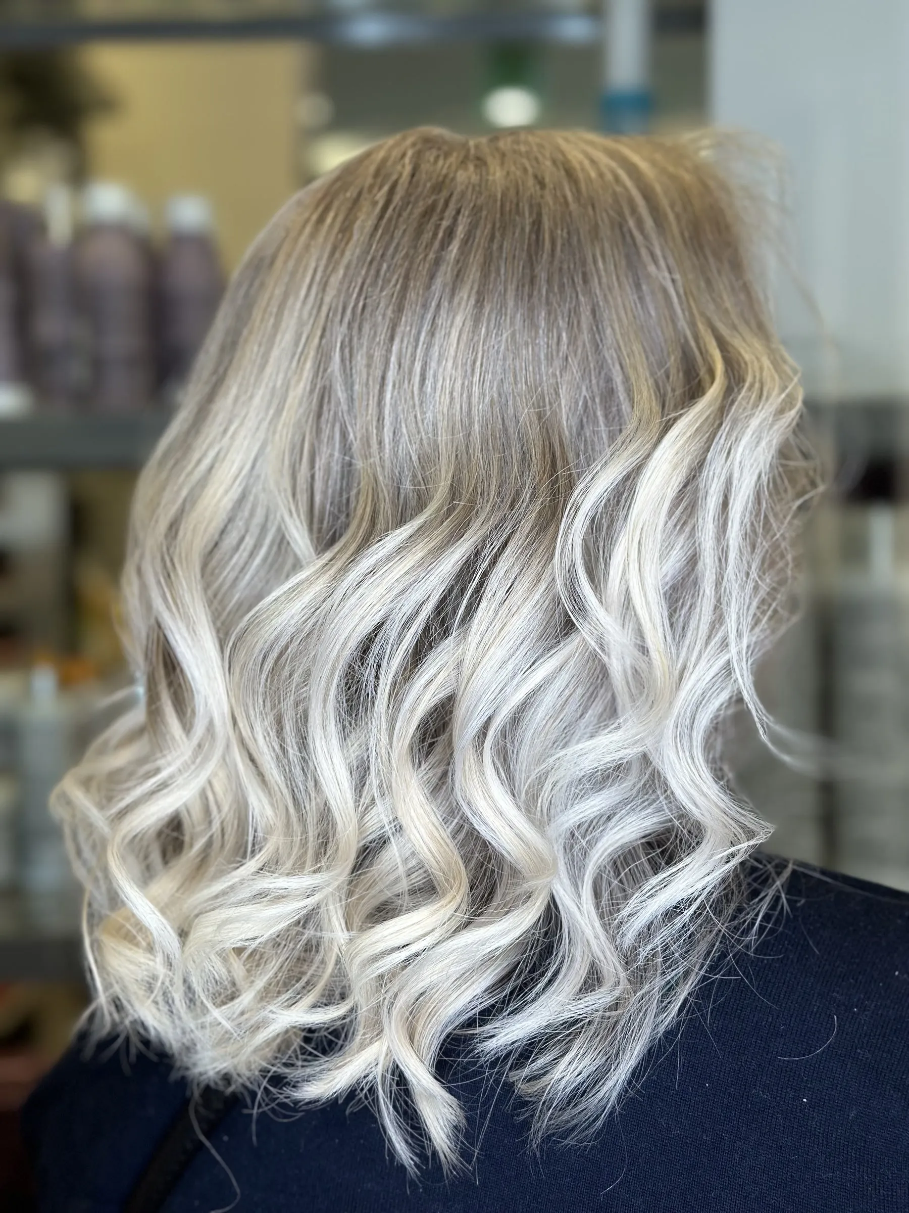 Bright icy blonde balayage on soft waves by Ronak Hairstylist in Toronto