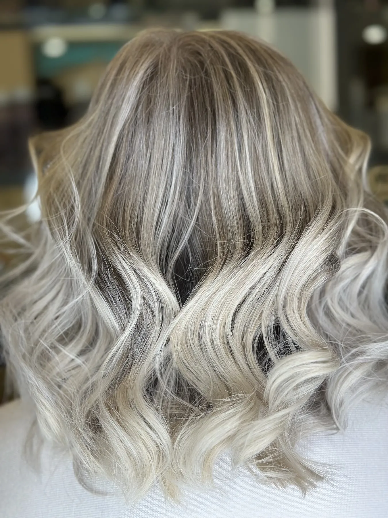 Ash blonde balayage on soft waves by Ronak Hairstylist in Toronto