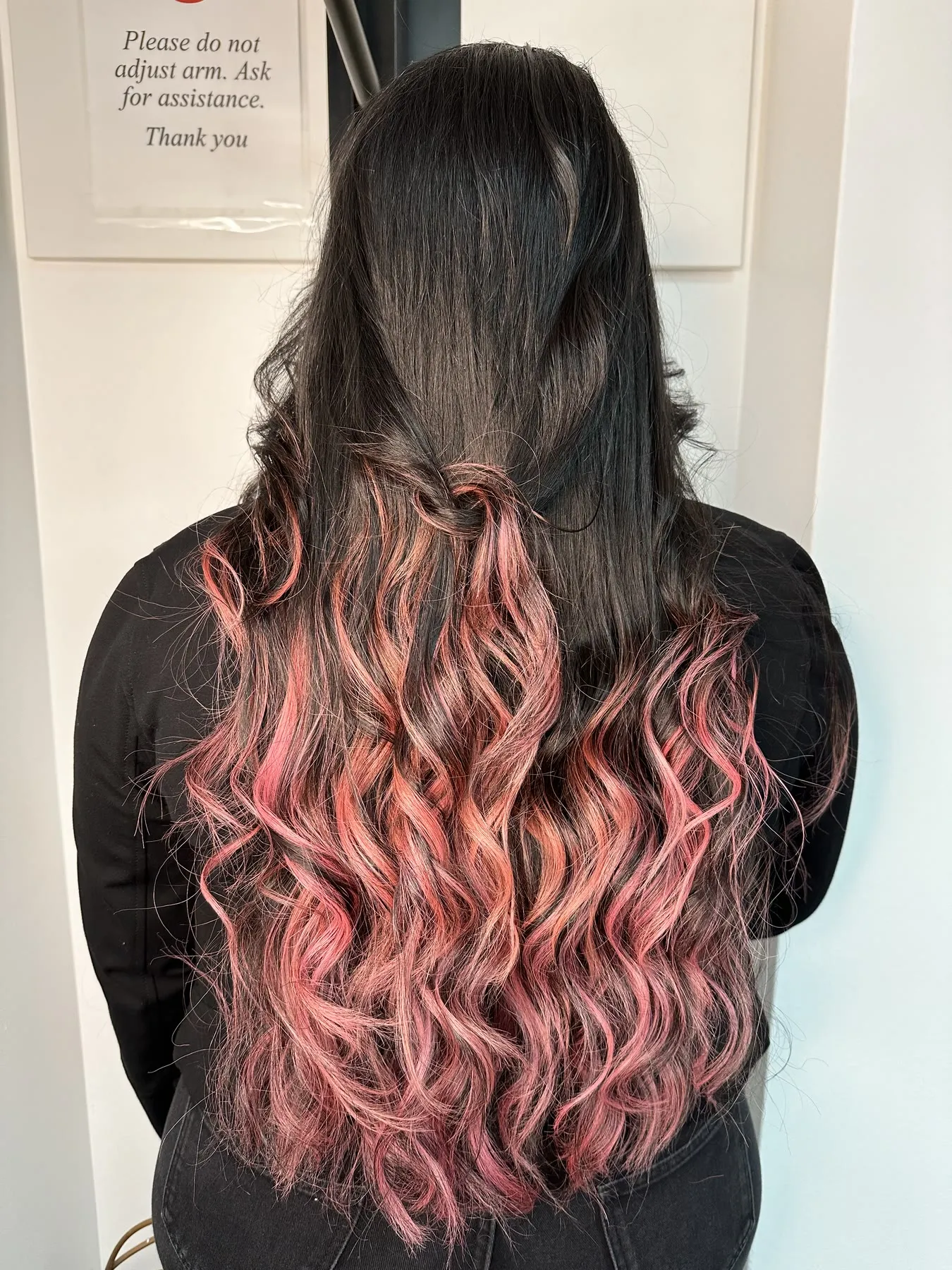 Black hair with vivid pink ribbon highlights by Ronak Hairstylist in Toronto