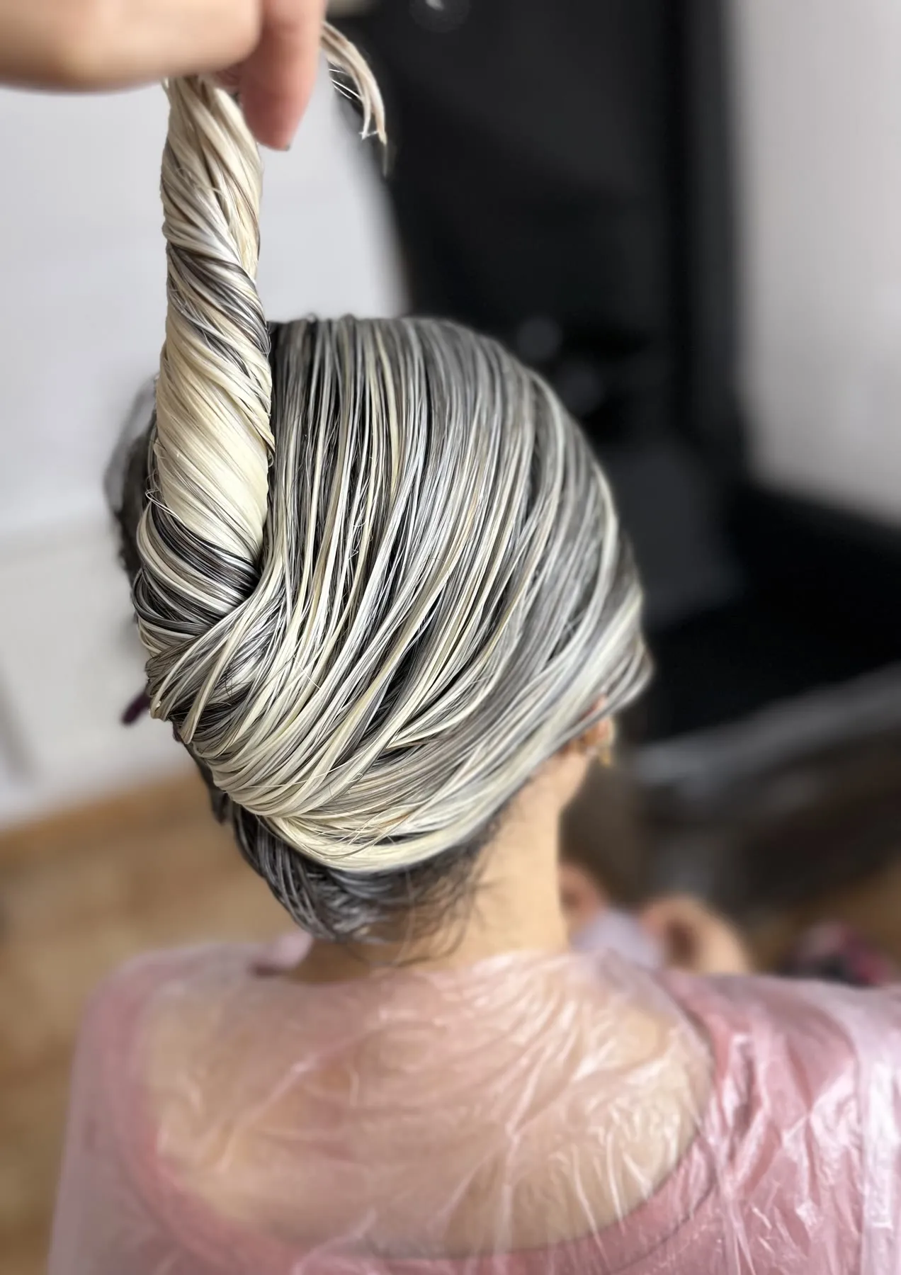 Silver-highlighted hair being twisted into an updo by Ronak Hairstylist in Toronto
