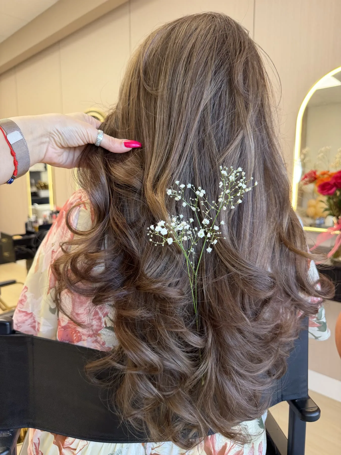 Half-up brunette curls finished with baby's breath by Ronak Hairstylist in Toronto