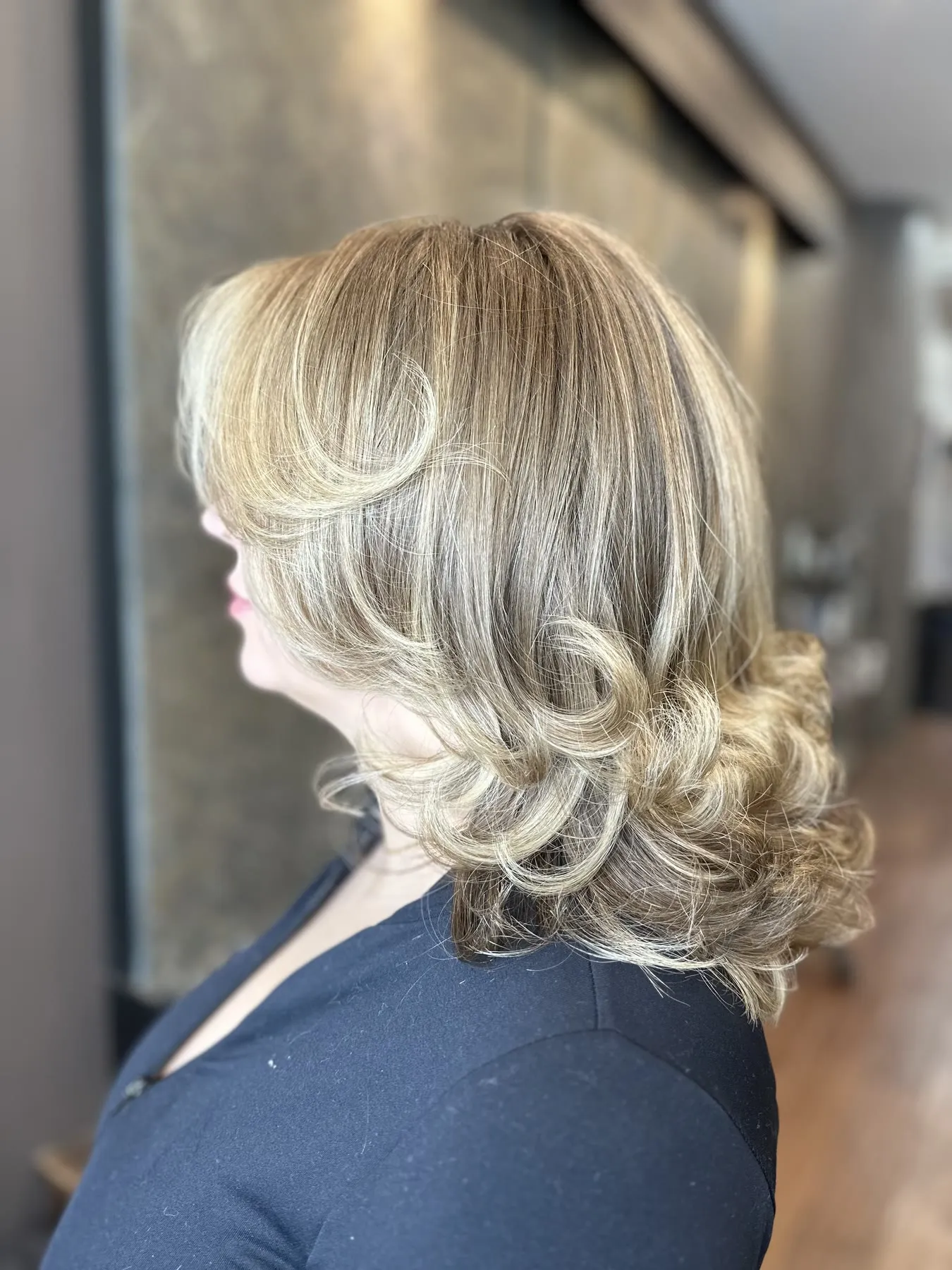 Layered blonde blowout with face-framing pieces by Ronak Hairstylist in Toronto